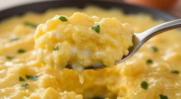 A spoon with a scoop of scrambled eggs on it photo