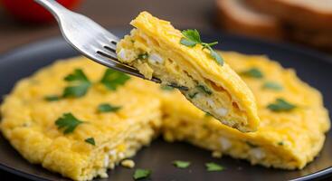 An omelet with cheese and herbs on a fork photo