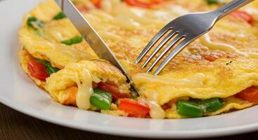 A fork is cutting into an omelet photo