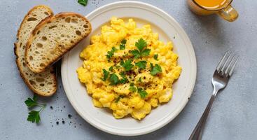 Scrambled eggs with bread and parsley on a plate photo
