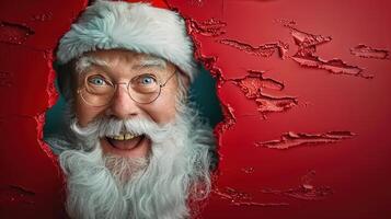 Santa Claus peeks through a textured red background with a wide, joyful expression. photo