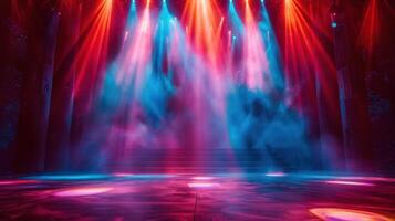 A brightly lit stage with red and blue lights shining dramatically through the smoke in a theatre. photo