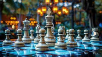 Wooden chess pieces arranged on a chessboard, with soft focus background lights in the distance. photo