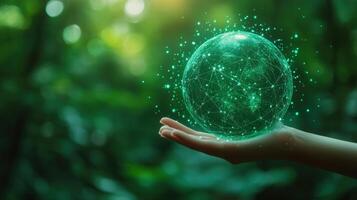 A hand cradles a glowing green digital sphere, representing a connected future in nature. photo