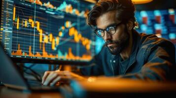 A serious trader studies financial charts and graphs displayed on multiple computer screens. photo