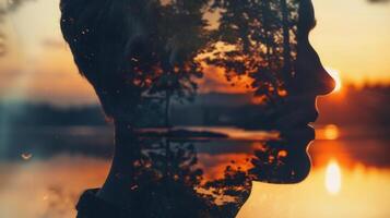 Double exposure artwork showing a person's silhouette overlaid with a scenic sunset view. photo