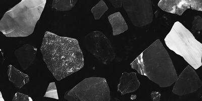 Mottled grayscale texture with scattered irregular shapes on a black background photo