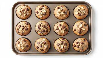 Delicious whole wheat muffins with chocolate chips and nuts in baking tray photo