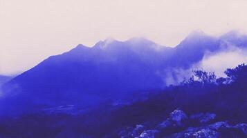 Indigo grunge mountain scene with mist and texture for artistic background design photo