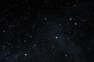 A dark sky with stars and some small lights photo