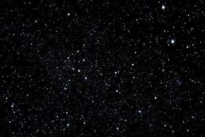 A black sky with stars and some small white dots photo