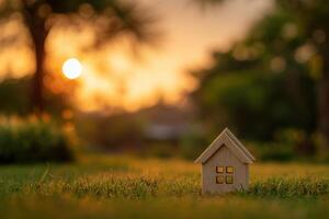 A small wooden house sits in the grass at sunset photo