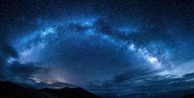 The milky way over the mountains in the night sky photo