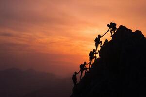Silhouette of people climbing the mountain at sunset photo