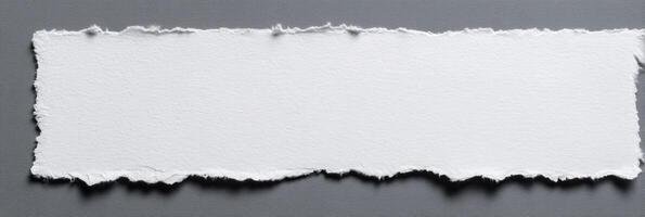 Torn Paper Piece for Textured Background and Craft Paper with Rough Edges for Scrapbooking and Design Templates on Gray Surface photo