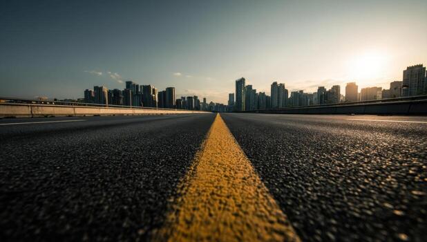 A long empty road with a city skyline in the background photo