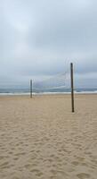 A volleyball net on a beach with sand photo