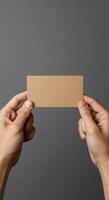 Hands holding a blank piece of paper on a gray background photo