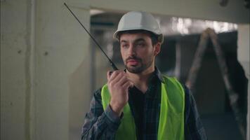 Professional Caucasian builder guy talking walkie talkie in construction electrician man foreman holding tech input engineer inspector communicating radio set male controller inspection build control video