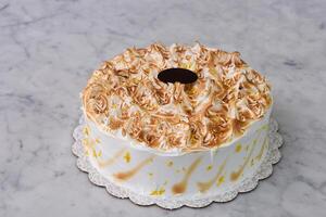 Toasted Lemon Meringue Layer Cake featuring moist cake layers with a tangy lemon filling isolated on grey background side view of sweet dessert photo