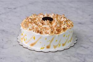 Toasted Lemon Meringue Layer Cake featuring moist cake layers with a tangy lemon filling isolated on grey background side view of stunning dessert photo
