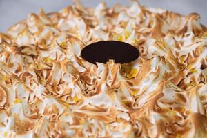 Toasted Lemon Meringue Layer Cake featuring moist cake layers with a tangy lemon filling isolated on grey background closeup top view of stunning dessert photo