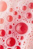 Close-up view of vibrant red bubbles and foam creating a textured surface, showcasing the interplay of light and color in a visually captivating composition photo