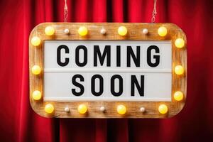 Vintage marquee sign with bright lights displaying the phrase Coming Soon against a rich red curtain backdrop, creating an inviting atmosphere for upcoming events or announcements photo