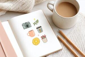 Flat illustration featuring a cozy workspace with a notebook displaying colorful doodles, a cup of coffee, and pencils, creating a warm and inviting atmosphere for creativity photo