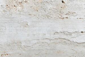 Textured grainy concrete surface with subtle variations in color and pattern, showcasing natural imperfections and a rugged aesthetic for design and architectural applications photo