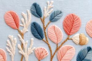 Colorful embroidery design featuring intricate floral patterns with various leaves and textures on a soft blue fabric background, showcasing artistic craftsmanship and creativity photo