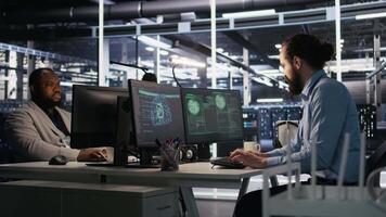 engenheiro dentro servidor quarto respondendo para de repente ransomware detecção em monitor, solicitando Socorro a partir de Gerente para proteger crítico dados. trabalhador revendo suspeito atividade Histórico, informando equipe líder, Câmera uma video