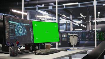 Mockup computer in high tech data center office used for AI system monitoring and performance tracking. Green screen PC overseeing server rigs involved in computing operations video