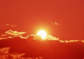 The sun is shining brightly through a cloud covered sky photo