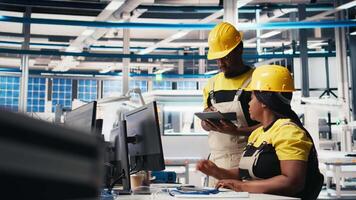 African american team of employees doing quality control on pc, troubleshooting and fixing technical issues for solar panel production at the factory. Coworkers inspecting system. Camera B. video