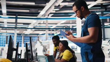 Supervisor in solar panel factory investigating potential malfunctioning systems, reading paperwork and user manuals. Inspector ensuring seamless production, reducing downtime. Camera B. video
