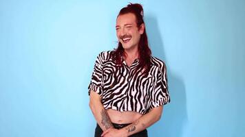 Non-binary person laughing on blue background video
