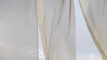 Light breezy sheer curtain blowing in the wind with cloudy sky behind it video