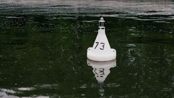 A buoy marked 73 floats on the calm, dark waters, capturing the essence of tranquility in this idyllic setting video