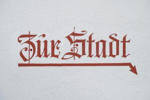 Sign zur Stadt to the town center with arrow pointing downwards photo