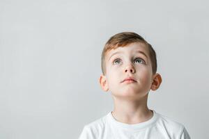 Young boy looking up with a hopeful expression on his face photo