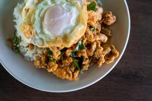 Stir fried pork with red curry paste and egg on rice photo