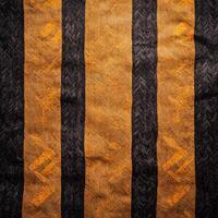 A black and orange striped fabric with a black and white pattern photo