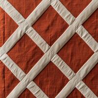 A quilted orange and white quilt with a diamond pattern photo