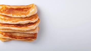 A stack of pancakes on a white surface photo
