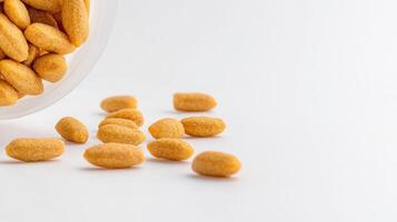 A bowl filled with orange candies on a white surface photo