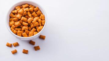 A bowl of orange dog food on a white surface photo