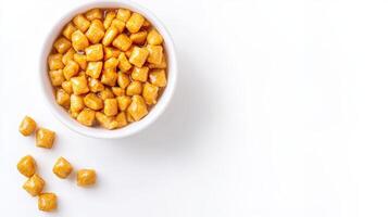 A bowl of popcorn with some pieces scattered around it photo