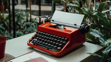 A red typewriter on a table with a cup of coffee photo