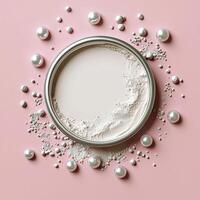 A white powder is surrounded by pearls on a pink background photo